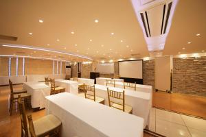 水戸市にあるホテル　シーズンの白いテーブルと椅子、黒板のレストランを併設しています。