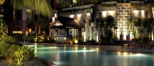 a swimming pool in front of a building at night at Kristal Hotel Jakarta in Jakarta
