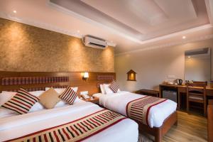 Pokój hotelowy z 2 łóżkami i biurkiem w obiekcie Kuti Resort & Spa w mieście Pokhara