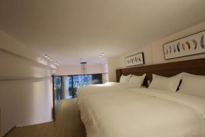 a bedroom with a large white bed and a window at Yongke International Duplex Apartment in Guangzhou