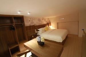 una habitación de hotel con una cama y una mesa con flores en Yongke International Duplex Apartment, en Guangzhou