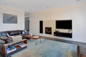 a living room with a couch and a flat screen tv at Treehouse Jervis Bay in Vincentia