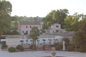 une maison avec une fontaine et une statue dans une cour dans l'établissement Villa Collio Relais, à San Severino Marche