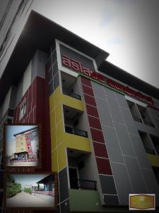 a large building with a sign on the side of it at Siri Sothorn Apartment in Chachoengsao