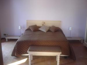 a bedroom with a bed with two tables and two lamps at Villa Collio Relais in San Severino Marche