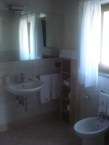 a bathroom with two sinks and a mirror at Villa Collio Relais in San Severino Marche