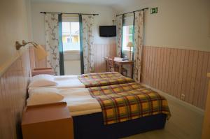 una camera d'albergo con letto e TV di Hotel Strandbo a Nagu