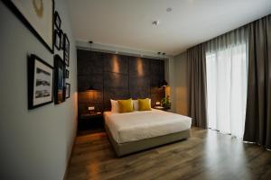 um quarto com uma cama grande e almofadas amarelas em RHR Hotel - Selayang em Batu Caves