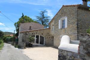 a stone house with a white couch in front of it at Montloubier in Villeneuve-de-Berg