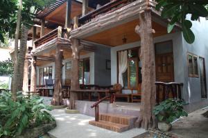 una casa con portico con tavoli e alberi di Big Fish Resort Koh Tao a Ko Tao
