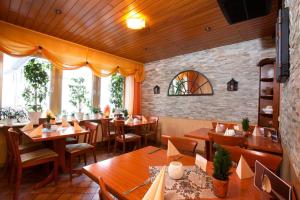 a restaurant with wooden tables and chairs and windows at Gasthaus zur Linde in Braunweiler