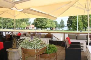 een patio met parasols, stoelen en planten bij Evedals Camping Växjö in Växjö