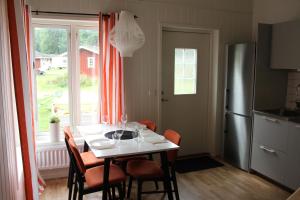 a kitchen with a table with chairs and a refrigerator at Evedals Camping Växjö in Växjö