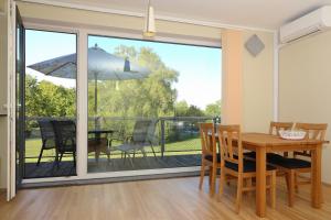 een eetkamer met een tafel en stoelen en een balkon bij Papli 34 Apartment with pool in Pärnu