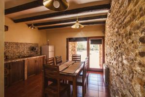 a dining room with a table and a stone wall at Alojamientos Rurales los Albardinales in Tabernas