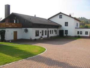 a large white building with a brick driveway at Ferienwohnungen Kuhbandner in Marktschorgast