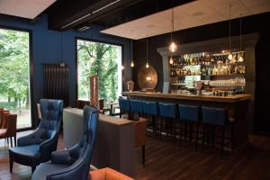 a restaurant with a bar with blue chairs at Parkhotel Schillerhain in Kirchheimbolanden