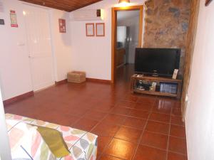 ein Wohnzimmer mit einem TV und Fliesenboden in der Unterkunft Monte Chabouco - Alojamento Local in Chabouco