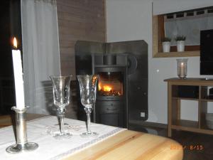 two wine glasses on a table in front of a fireplace at Grimm`s Waldhäuschen in Mudau