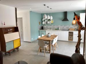 a kitchen with a wooden table and white cabinets at Pays des Senteurs in Saint-Ferréol-Trente-Pas