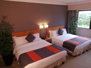 Postel nebo postele na pokoji v ubytování Kingwood Hotel Kuching