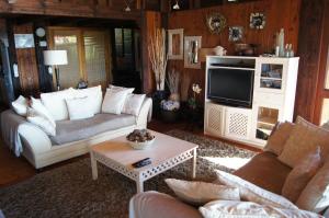 a living room with a couch and a tv at House 37 Nkululeko in Sodwana Bay Lodge - no loadshedding in Sodwana Bay