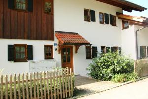 a white house with a wooden fence in front of it at FeWo Holzwarth Oberammergau in Oberammergau