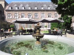 a fountain with a statue in front of a building at Abdij Hotel Rolduc in Kerkrade