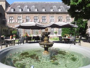 a fountain with a fountain umbrella in front of a building at Abdij Hotel Rolduc in Kerkrade