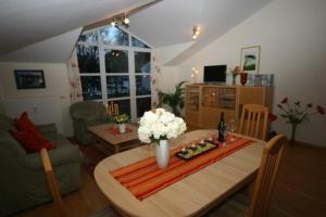 a living room with a table with flowers on it at Meeresblick Panorama Sauna Wlan Fi in Juliusruh