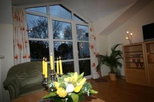 a living room with a couch and a table with flowers at Meeresblick Panorama Sauna Wlan Fi in Juliusruh