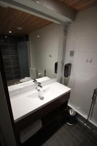 een badkamer met een wastafel en een grote spiegel bij Motel SEO Muonio in Muonio