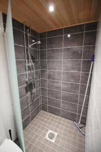 a bathroom with a shower with gray tiles at Motel SEO Muonio in Muonio