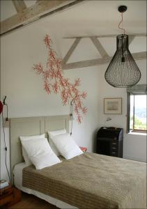 a bedroom with a bed with white pillows and a lamp at Jardin de Belle Vue in Quimperlé