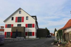 una casa bianca e rossa con garage di FeWo Daiber a Bad Schussenried