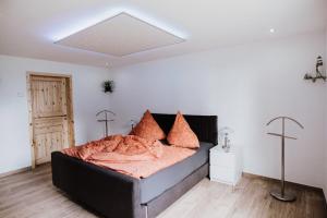 a bedroom with a bed with an orange blanket at Landhaus Boldevitz in Boldevitz