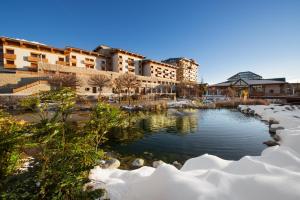 un étang recouvert de neige devant un bâtiment dans l'établissement Michlifen Resort & Golf, à Ifrane