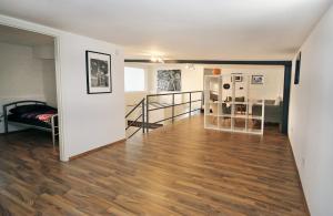 een lege woonkamer met een hardhouten vloer bij Loft-Unterkunft in Sinsheim