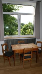 Hauset的住宿－Übernachten im ehemaligen Zollgebäude，窗户前的一张木桌和椅子