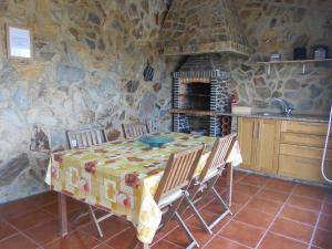 a kitchen with a table and a stone wall at Monte Chabouco - Alojamento Local in Chabouco