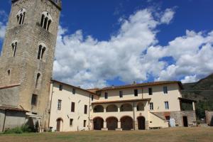Ostello di Camaiore في كامايوري: مبنى فيه برج ومبنى فيه سماء