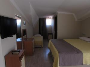 a hotel room with two beds and a flat screen tv at Dogan Apart Hotel in Göcek