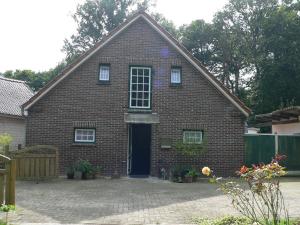 a red brick house with a blue door at Ferienhaus Zum grünen Holz in Zetel