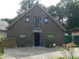 une maison en briques rouges avec une porte bleue dans l'établissement Ferienhaus Zum grünen Holz, à Zetel