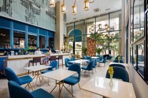 a restaurant with blue chairs and tables and a bar at Lavis 18 Residence in Ho Chi Minh City