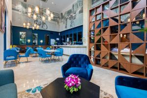 a lobby with blue chairs and tables and a bar at Lavis 18 Residence in Ho Chi Minh City