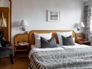 um quarto com uma cama grande e almofadas em Hotel Guter Tropfen em Hagnau