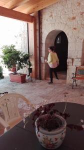 una mujer está de pie en una habitación con una mesa en B&B Masseria Spilafemine, en Turi