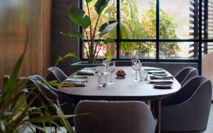 a table in a restaurant with glasses and chairs at Sir Anthony in Playa de las Americas