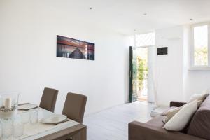 un soggiorno bianco con tavolo e divano di The Imperial Suite a Roma